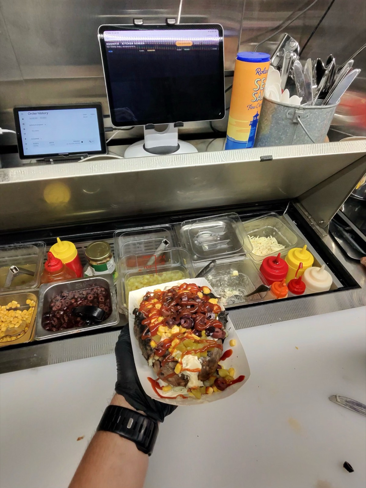 Giant loaded kumpir baked potato held in hand Miami