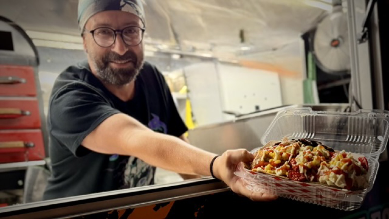 Chef serving fresh kumpir from Koompir food truck window