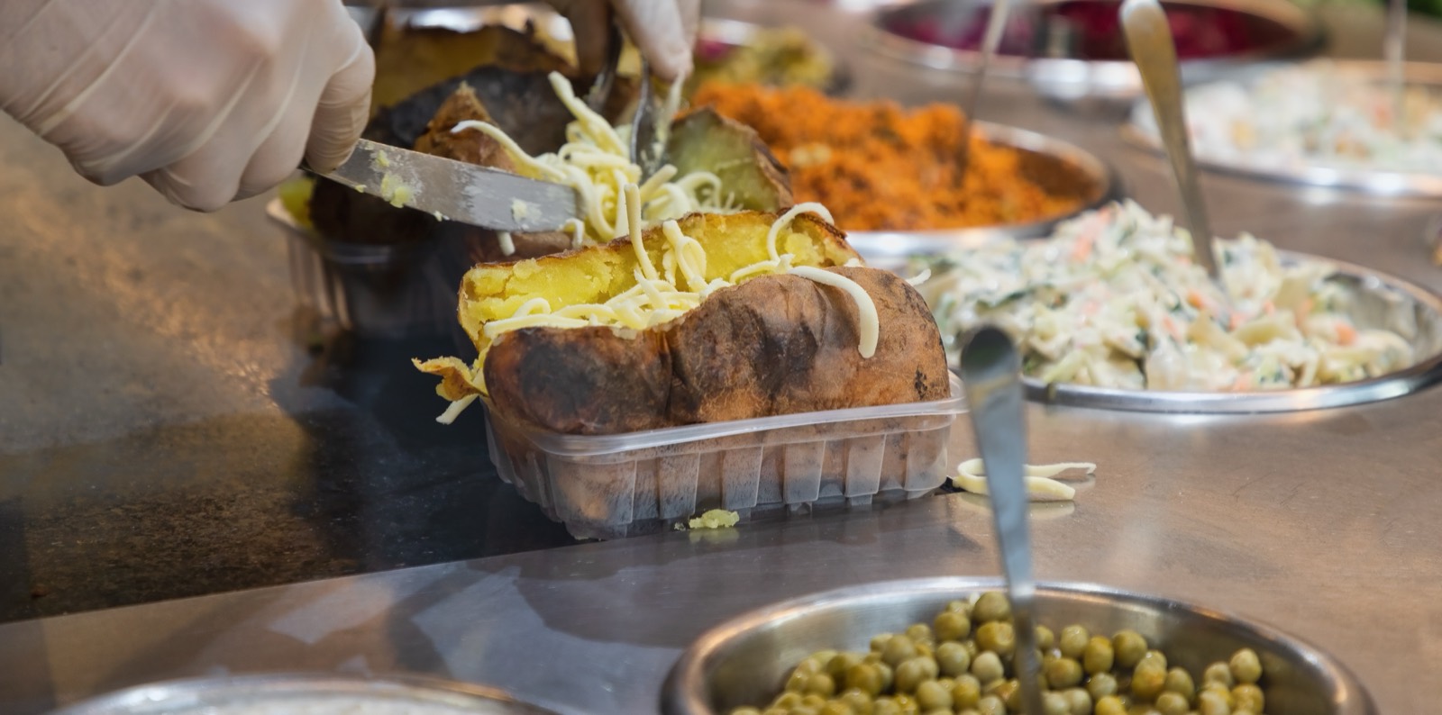 Splitting open a giant baked potato and mashing in butter and cheese